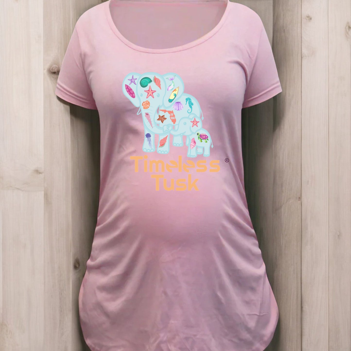 Flat lay of the maternity shirt alongside seashells and eco-friendly packaging, emphasizing sustainability.